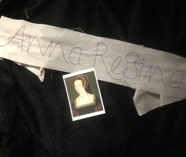 Embroidered fabric with the words Anna Regina and a postcard of Anne Boleyn